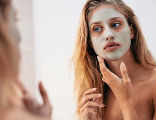 Mum looking in the mirror putting on a clay face mask