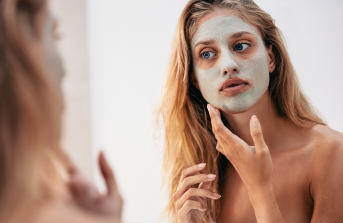 Mum looking in the mirror putting on a clay face mask