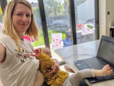 Rachel feeds her baby while working from home